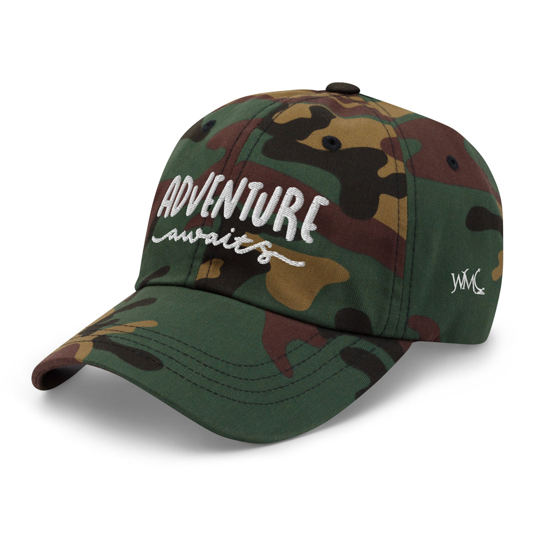 Classic camo cap style with the words Adventure Awaits embroidered on the front in white font.