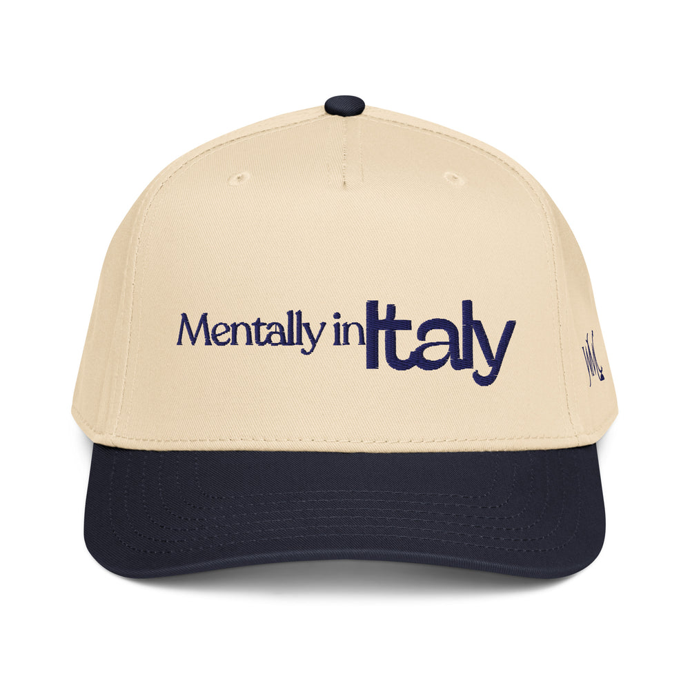 Five panel beige and navy Otto cap with the words Mentally in Italy embroidered with navy colored font on the front of the cap. The word Italy stands out in large font. The crown of the cap is beige while the bill is black.