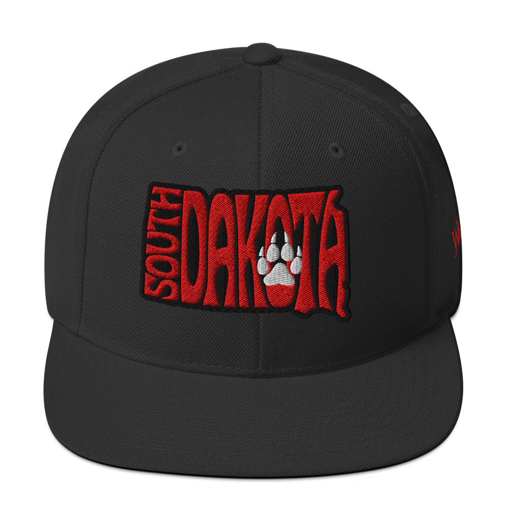 South Dakota’s history is rooted in its Native American heritage, particularly the Lakota Sioux, and later shaped by the Black Hills Gold Rush of the 1870s. It became a U.S. state in 1889, gaining recognition for its agriculture, rugged landscapes, and landmarks such as Mount Rushmore. This snapback cap represents the rich history of South Dakota along with the college sports pride.
