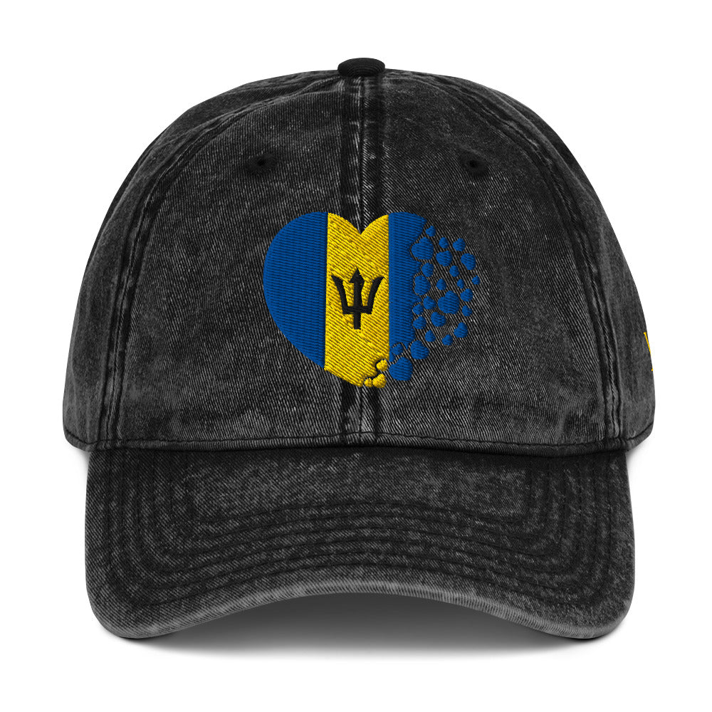 Black Barbados themed vintage classic cap which features the Barbados flag inserted into the shape of a heart.

Barbados Flag Breakdown:
The blue represents the sea and sky surrounding the island.
The gold represents the sand and sun of Barbados’ beaches.
The black broken trident symbolizes breaking away from its colonial past and becoming independent in 1966.