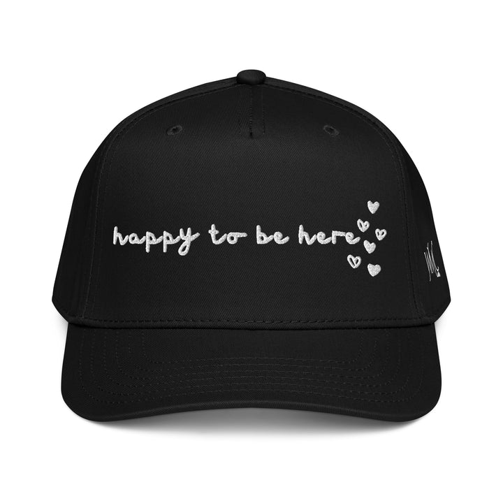 Five panel black Otto cap with the words Happy To Be Here embroidered in black font on the front of the cap