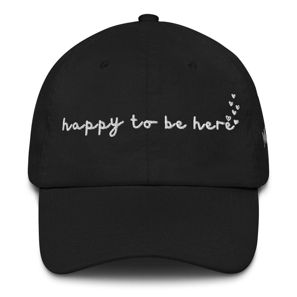 Classic Yupoong dad hat with the words Happy To Be Here embroidered on the front. The back of the cap features an adjustable strap with an antique buckle.