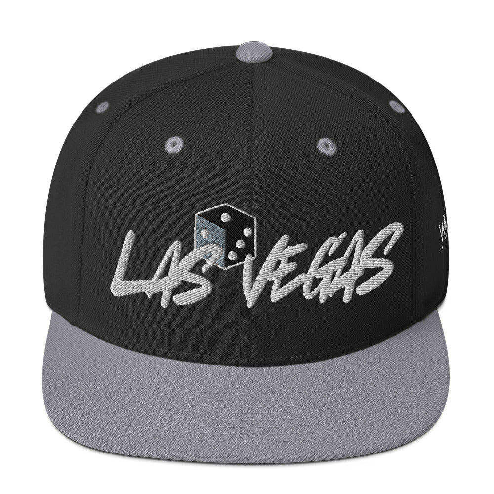 Black and gray snapback cap - perfect accessory for your next Las Vegas trip. Las Vegas, founded in 1905 and officially incorporated in 1911, transformed from a desert railroad stop into the entertainment capital of the world. Over the decades, Vegas became synonymous with glamorous shows along with the famed Las Vegas Strip.